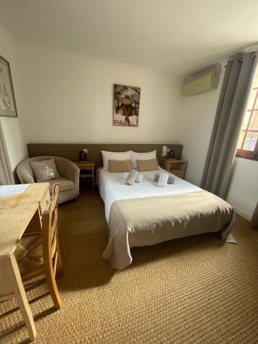 a bedroom with a large bed and a couch at La Passiflore in Vergèze