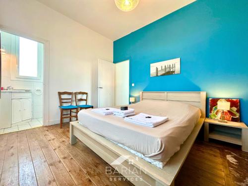 a bedroom with a large bed with a blue wall at Bord de mer 60 m - Charmante Maison 5 personnes in Fouras