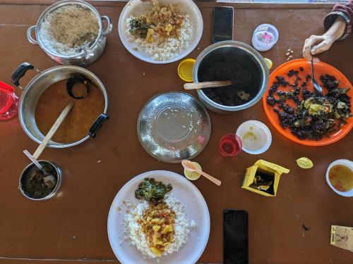a wooden table with plates of food and bowls of food at Healing Home And Hostel Auroville in Puducherry