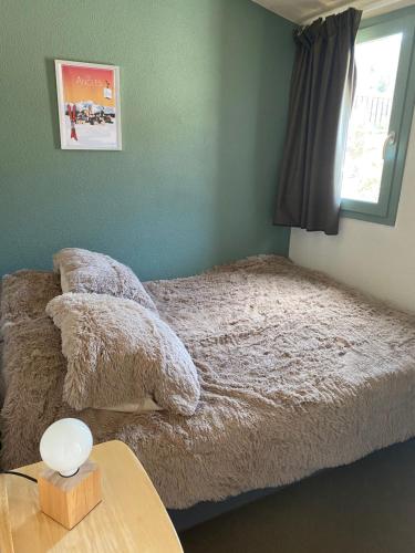sypialnia z łóżkiem ze stołem i oknem w obiekcie Charmant appartement avec parking privé dans une petite résidence très calme w mieście Les Angles