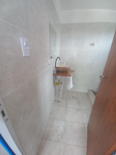 a white bathroom with a sink and a shower at Complejo DYE in Bialet Massé