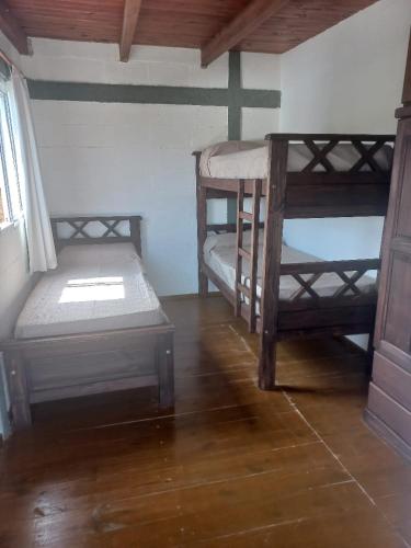 a room with two bunk beds and a bench at Complejo DYE in Bialet Massé