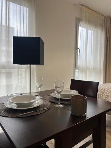 - une table à manger avec 2 assiettes et des verres à vin dans l'établissement Studio de 25m2 à proximité immédiate de Paris Expo, Porte de Versailles, à Malakoff