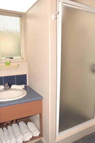 a bathroom with a shower and a sink at MALFROY Motor Lodge Rotorua in Rotorua