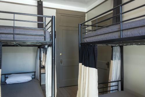 a bedroom with two bunk beds in a room at Gardner Hotel & Hostel in El Paso