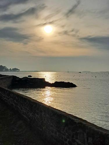 a sun setting over a body of water at Les reflets du golfe in Arradon