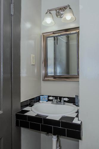 a bathroom with a sink and a mirror at Gardner Hotel & Hostel in El Paso