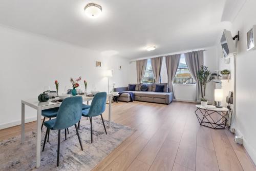 a living room with a table and chairs and a couch at The Queensborough Apartments by Hyde Park in London