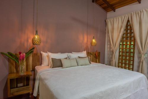 a bedroom with a white bed and a window at P2 Tucan in Talamanca
