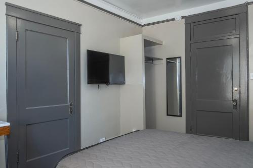 a bedroom with a bed and a flat screen tv at Gardner Hotel & Hostel in El Paso