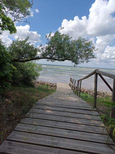a wooden boardwalk leading to the beach at Viesu māja"Ordziņas" in Pāvilosta