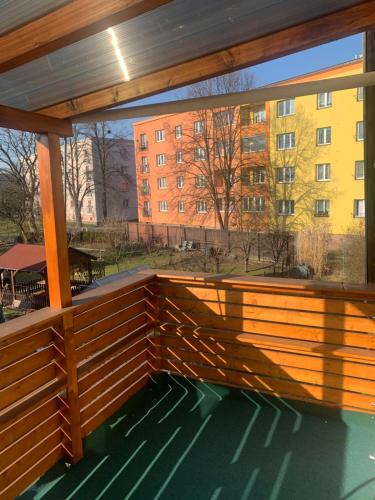 a large wooden deck with a view of a building at Apartmán v rodinném domě in Výškovice