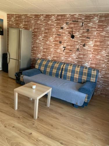 a living room with a blue couch and a refrigerator at Apartmán v rodinném domě in Výškovice