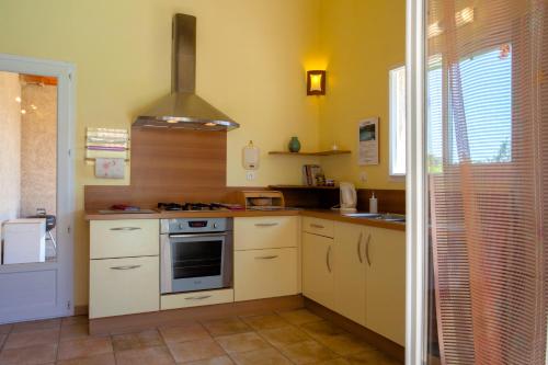 une cuisine avec des armoires blanches et un four à plaques de cuisson dans l'établissement Casa di Luiggi, à Venaco