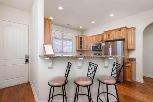 a kitchen with two bar stools and a refrigerator at Panoramic Penthouse at SDC in Branson
