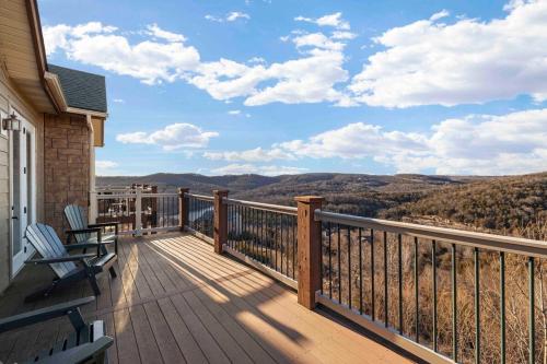 a deck with two chairs and a view of the mountains at Panoramic Penthouse at SDC in Branson