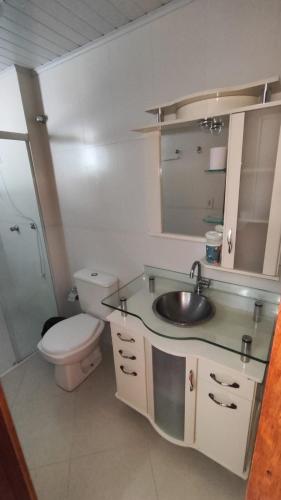 a bathroom with a sink and a toilet and a shower at Half Beach Apartment - Itapema in Itapema