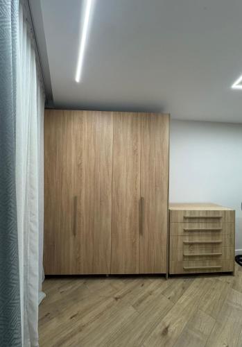a room with wooden cabinets and a white wall at Port View Apartment 2 in Durrës