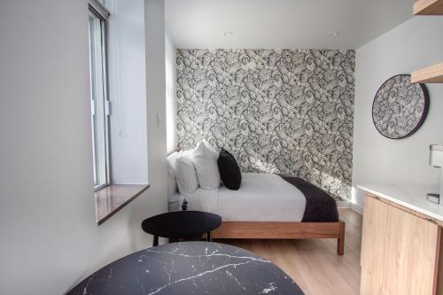 a bedroom with a bed with a patterned wall at Studio #9 - Self Check-In - Plateau - St-Denis in Montreal