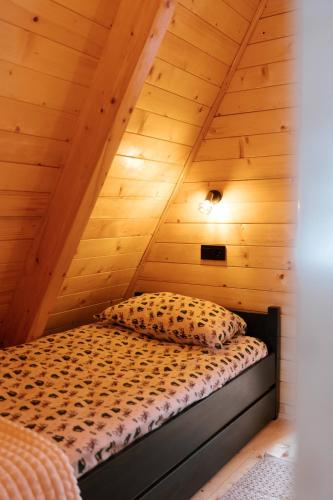 a bed in a room with a wooden ceiling at Vikendica miRAJ Manjaca in Gornje Ratkovo