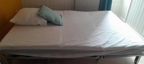 a bed with white sheets and two pillows on it at Au Bon oranger, Appartement en coeur de ville hyper centre in Cholet