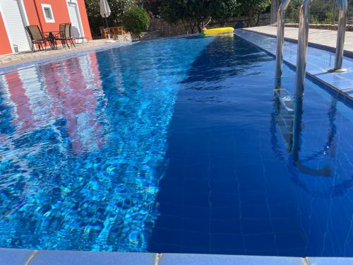 a large blue swimming pool with blue water at Dans une villa avec piscine privée, calme, proche des plages, vues mer et montagnes in Tsivarás