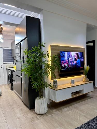 a living room with a tv on a wall at Pebbles Nest in Kwabenya
