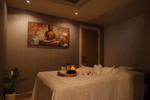 a table in a room with a painting on the wall at MoonBasa Boutique Hotel and Spa Infopark , Kakkanad in Cochin