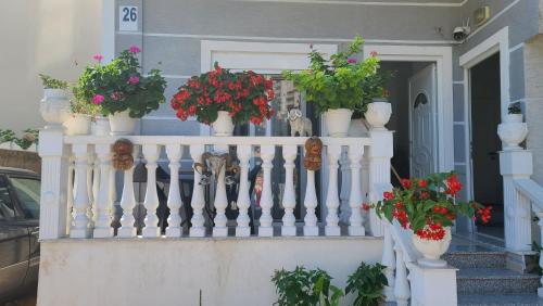 a white railing with potted plants on it at Luxury Room's by Lika in Sarandë