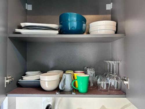 a shelf with plates and bowls and other dishes at Pebbles Nest in Kwabenya