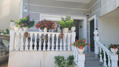 a porch with potted plants on a white railing at Luxury Room's by Lika in Sarandë