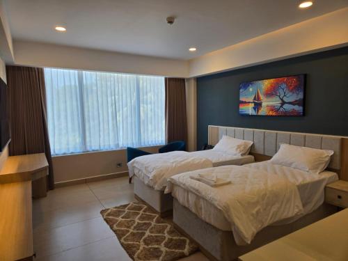 a hotel room with two beds and a tv at MoonBasa Boutique Hotel and Spa Infopark , Kakkanad in Cochin