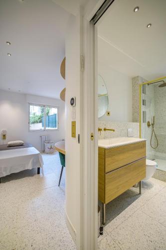 une salle de bain avec une baignoire et un lavabo et un lit dans l'établissement Perle rare au coeur de la pinede, à Antibes