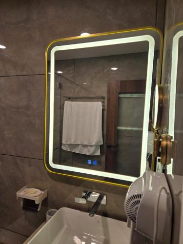 a bathroom with a sink and a large mirror at MoonBasa Boutique Hotel and Spa Infopark , Kakkanad in Cochin