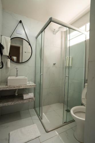 a bathroom with a glass shower and a toilet at Hotel Pipa Atlântico in Pipa