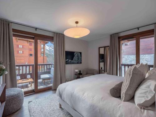 une chambre avec un grand lit et un balcon dans l'établissement Chalet de Luxe avec Sauna et Jacuzzi, Proche Pistes et Centre de Courchevel - FR-1-563-142, à Courchevel