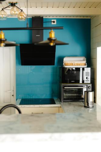 a kitchen with a blue wall and a counter at Вілла у горах in Krasnik