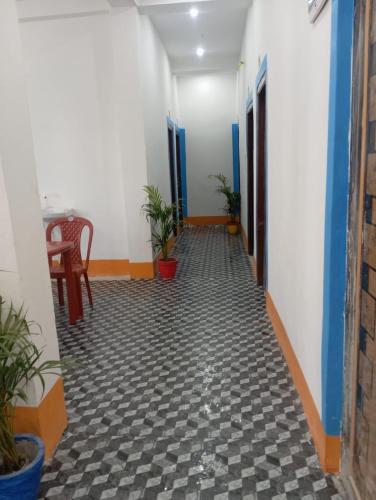 a hallway with a table and plants in a room at TabTrips Laxmi Resort in Bāghmundi