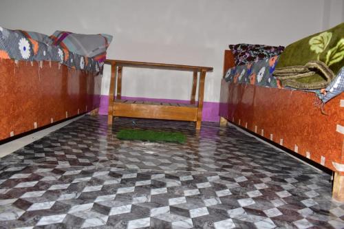 a room with two beds and a checkered floor at TabTrips Laxmi Resort in Bāghmundi