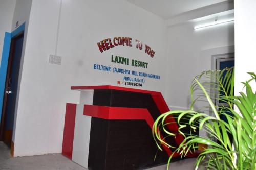 a wall with a sign that reads welcome to the law institute at TabTrips Laxmi Resort in Bāghmundi
