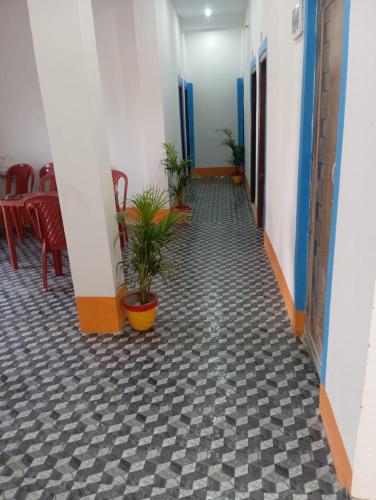 a hallway with chairs and plants in a room at TabTrips Laxmi Resort in Bāghmundi