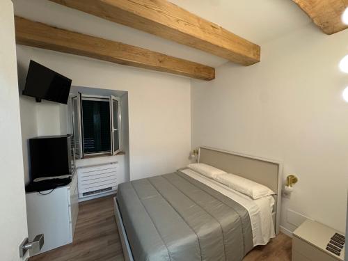 a bedroom with a bed and a flat screen tv at La Dimora del Borgo in Montecassiano