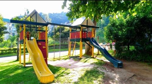 a playground with a slide in the grass at Apto Casinha de Boneca no Verde in Itaipava