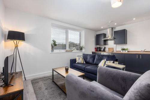 a living room with a blue couch and a kitchen at 1 Bedroom Flat Near Bradford With Free Parking in Saltaire