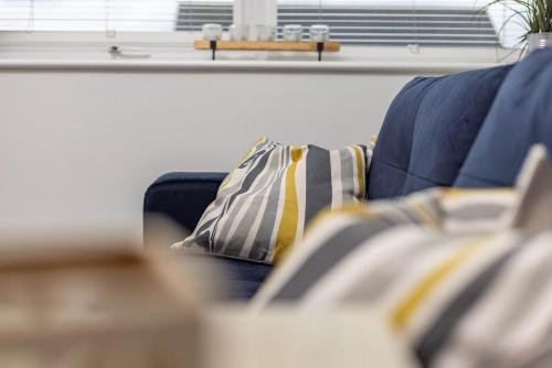 a blue couch with striped pillows in a living room at 1 Bedroom Flat Near Bradford With Free Parking in Saltaire