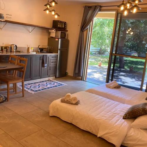 a bedroom with a bed and a table and a kitchen at סוויטת לורד הרמיטאז' בגולן in Bruchim Qela' Alon