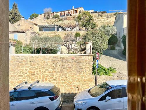 two white cars parked next to a stone wall at Lou Miradou 2 - Vieux village médiéval, Cosy, Clim, 2 personnes in Miramas