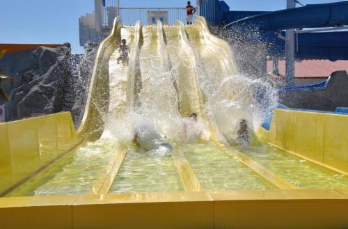 people playing in a water slide at a water park at Mobil-home 40m2, camping les Charmettes 4 étoiles La Palmyre 4-6 personnes-2 chambres dont 1 suite parentale-2 salles de bain in Les Mathes