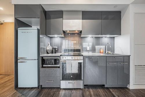 a kitchen with stainless steel appliances and a refrigerator at 2BR Condo close to Eaton Center in Toronto