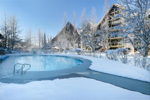 a swimming pool covered in snow in front of a building at The Aspens by Whistler Premier in Whistler